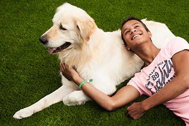 Man and dog lying on artificial turf
