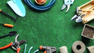 Maintenance and gardening tools lying on artificial grass