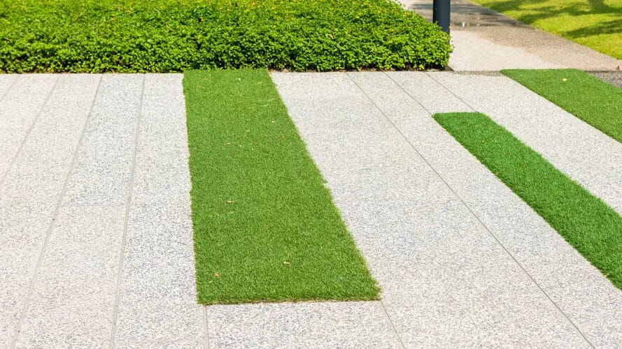 Artificial grass between concrete pavers