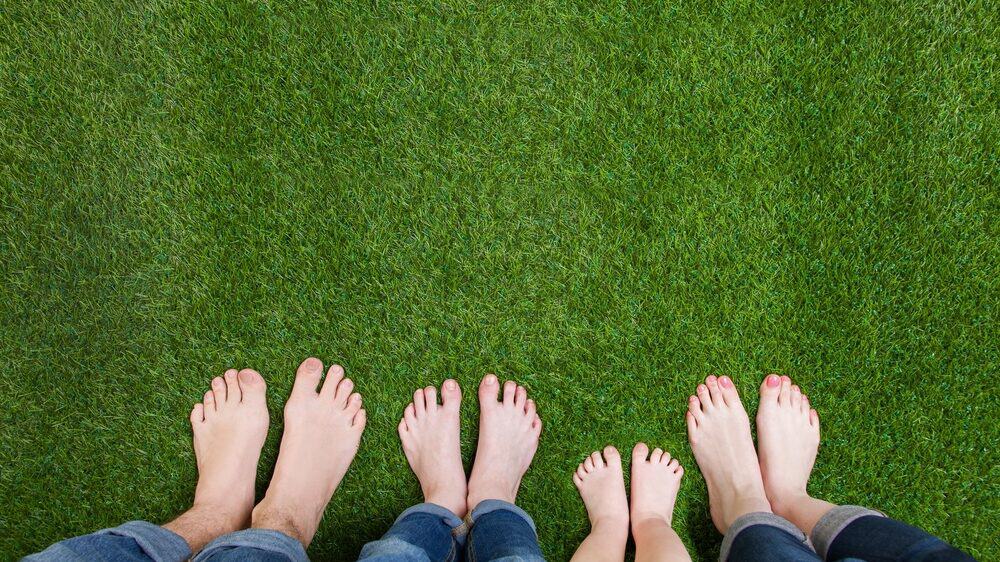 Family standing barefoot on artificial turf