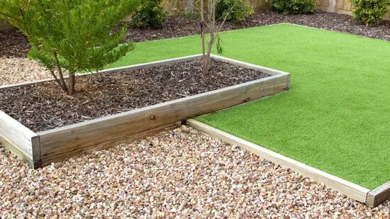 Artificial grass xeriscaping with stone and mulch garden bed