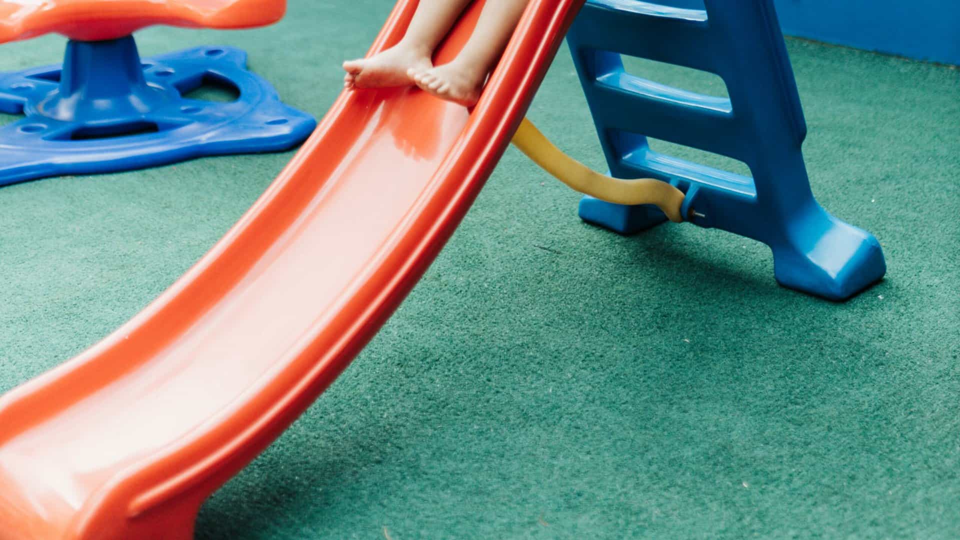Slide on artificial grass playground