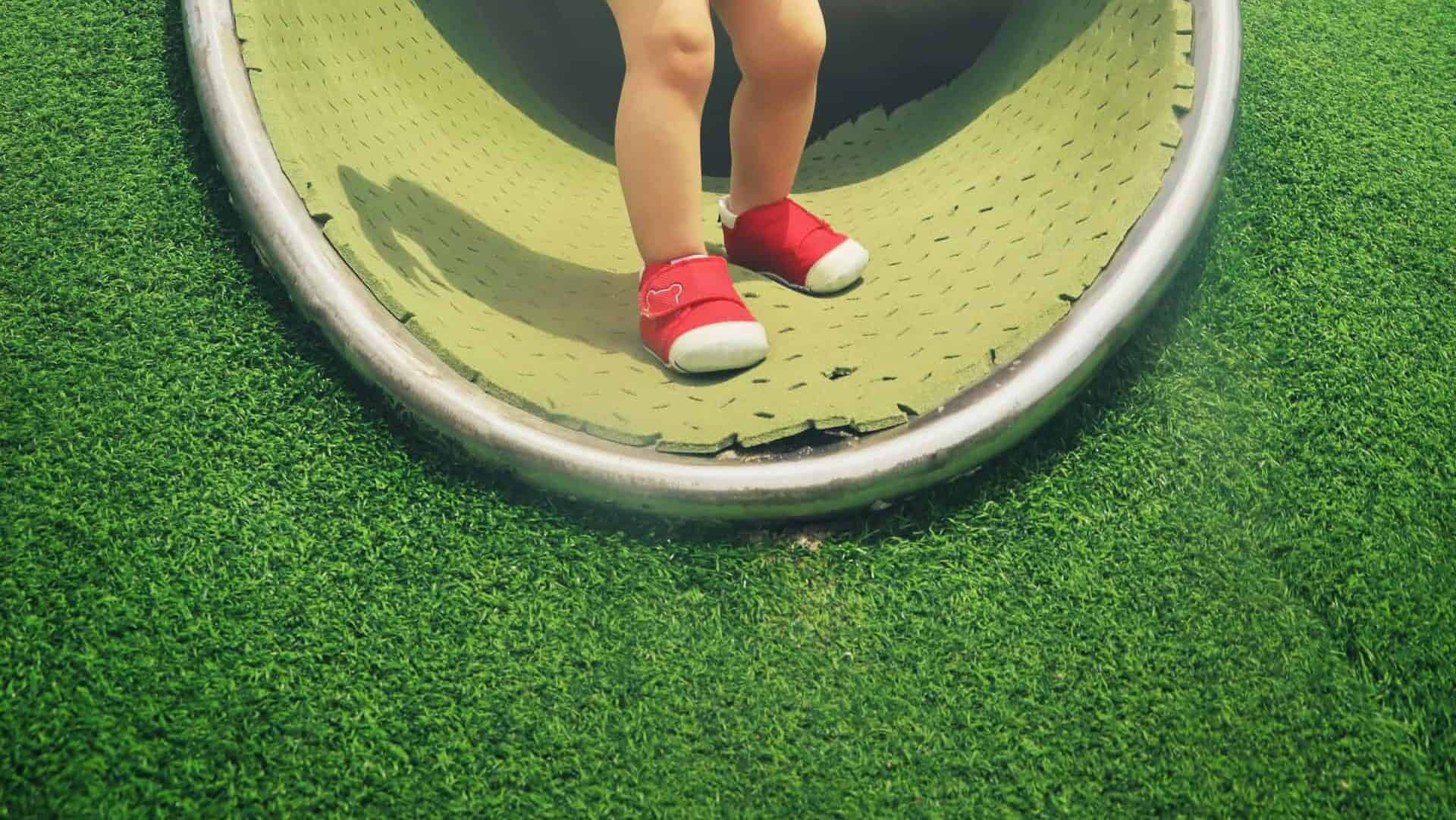 Tunnel on artificial grass sloped playground
